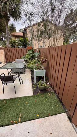 a view of a backyard with wooden fence and a bench