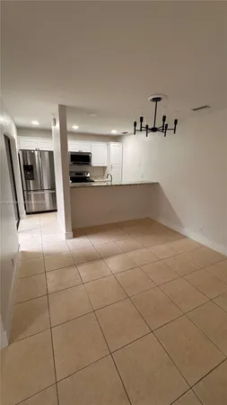 a kitchen with granite countertop a refrigerator and a stove top oven