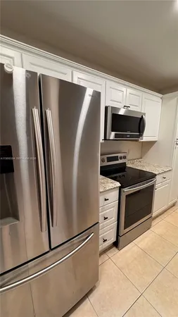 a view of kitchen with refrigerator and microwave