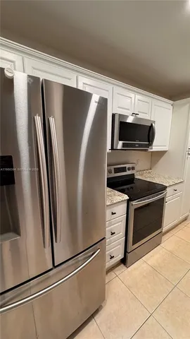 a view of kitchen with refrigerator and microwave