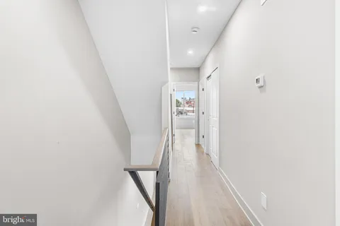 a view of a hallway with wooden floor and entryway