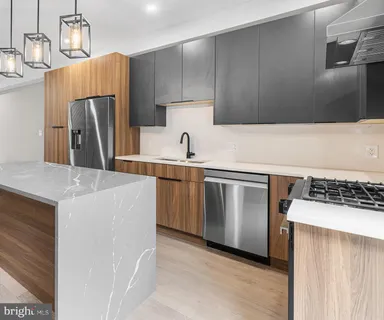 a kitchen with stainless steel appliances a sink a stove a refrigerator and cabinets