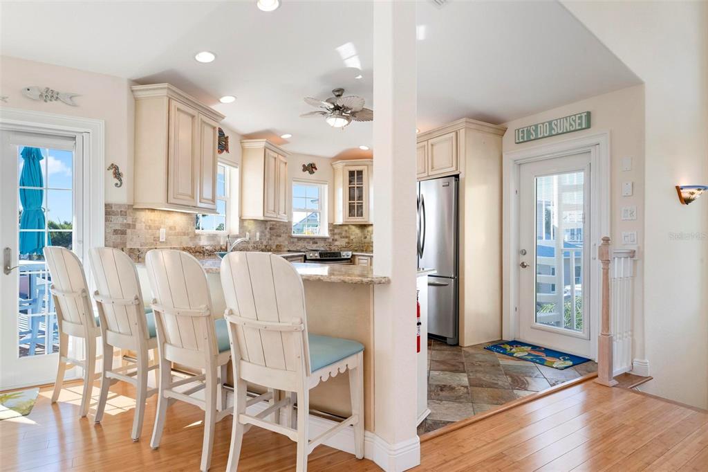 106 79th Street Holmes Beach, FL 34217 - Photo 12 of 98 a kitchen with stainless steel appliances kitchen island granite countertop a refrigerator and cabinets
