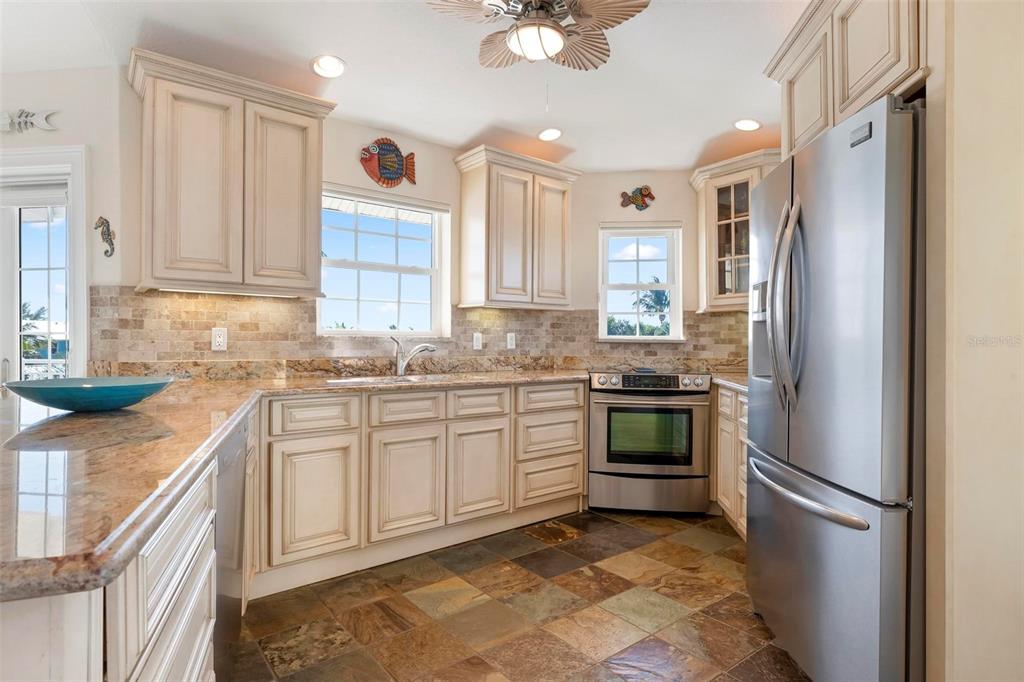 106 79th Street Holmes Beach, FL 34217 - Photo 13 of 98 a kitchen with stainless steel appliances granite countertop a refrigerator and a sink