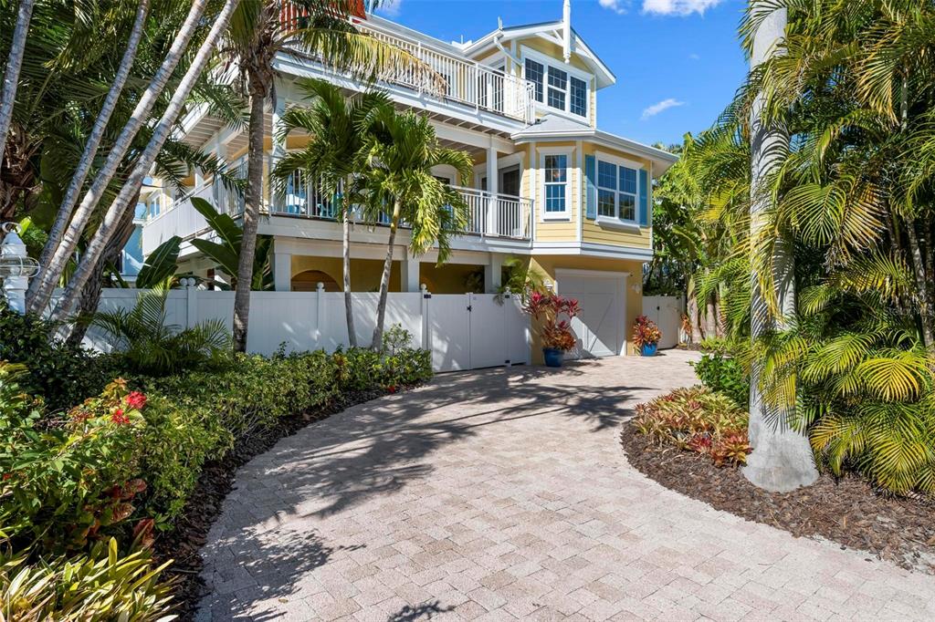 106 79th Street Holmes Beach, FL 34217 - Photo 4 of 98 a front view of a house with a garden