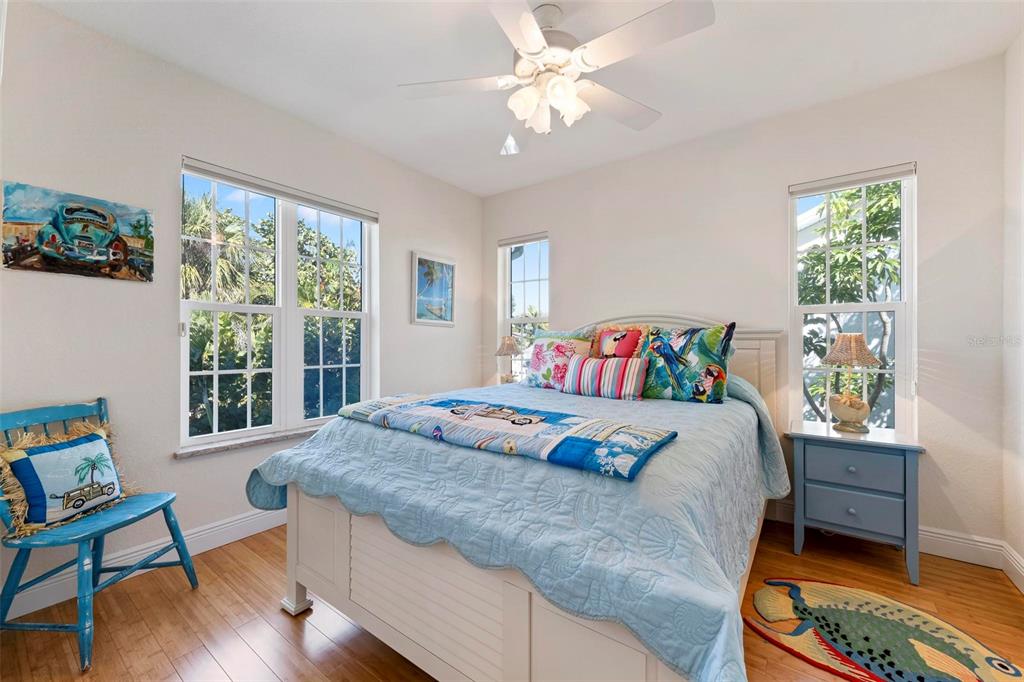 106 79th Street Holmes Beach, FL 34217 - Photo 42 of 98 a bedroom with a bed a table and a window