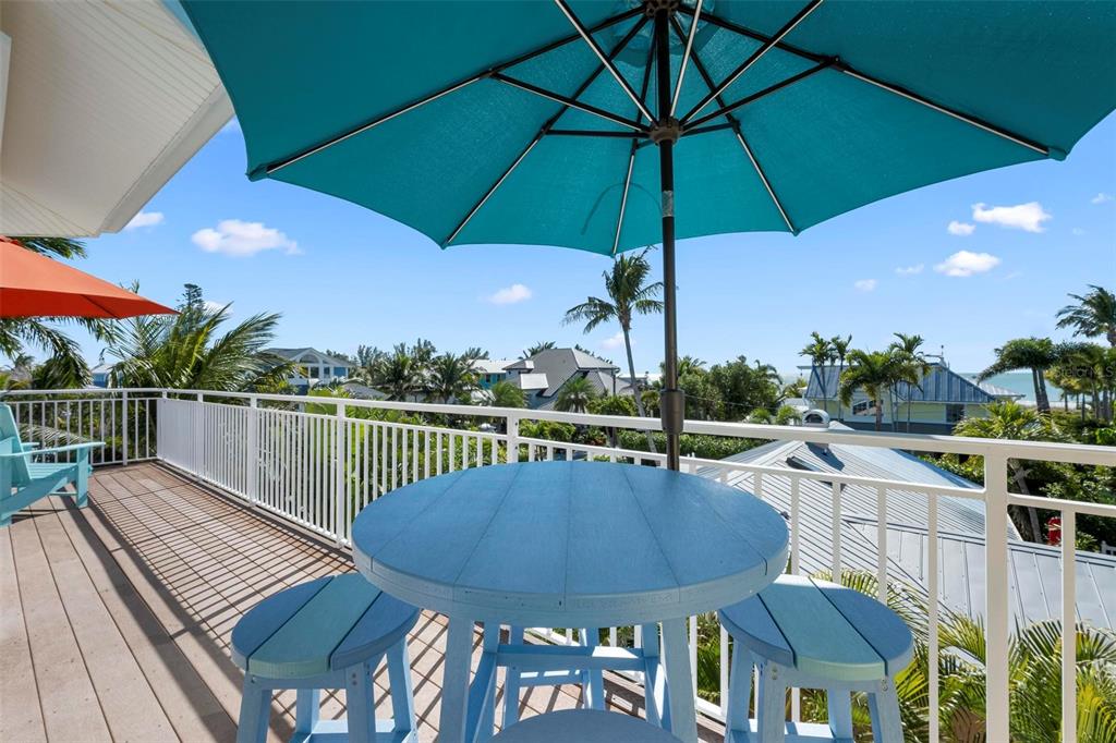 106 79th Street Holmes Beach, FL 34217 - Photo 54 of 98 a view of a balcony with wooden floor and outdoor seating