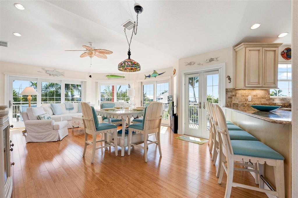 106 79th Street Holmes Beach, FL 34217 - Photo 6 of 98 a view of a dining room and livingroom with furniture wooden floor a chandelier