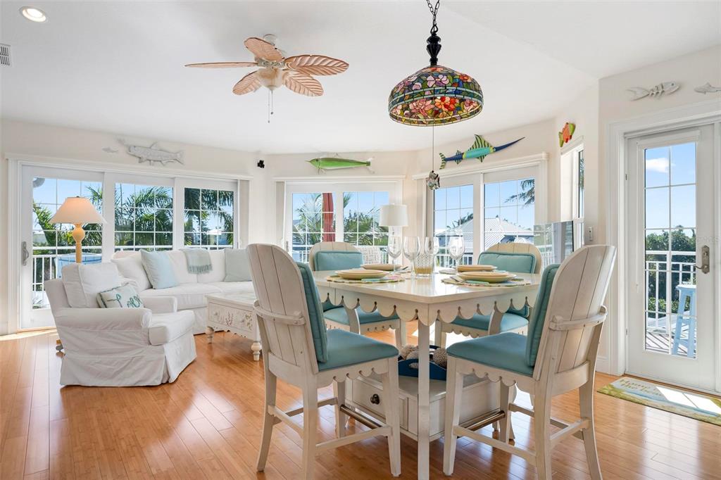 106 79th Street Holmes Beach, FL 34217 - Photo 7 of 98 a view of a dining room with furniture a chandelier and wooden floor