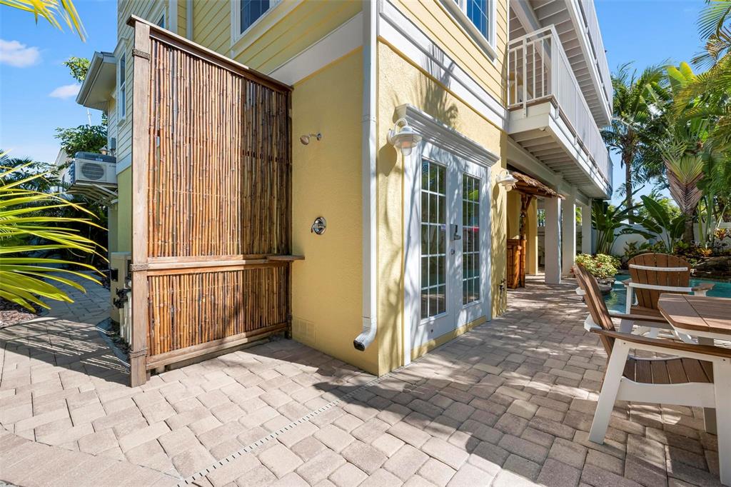 106 79th Street Holmes Beach, FL 34217 - Photo 71 of 98 a backyard of a house with barbeque oven table and chairs