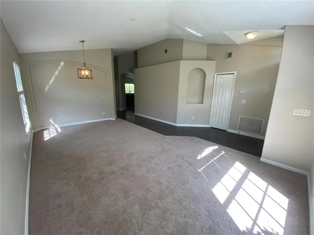 a kitchen with stainless steel appliances granite countertop white cabinets a sink dishwasher a stove and a refrigerator with wooden floor