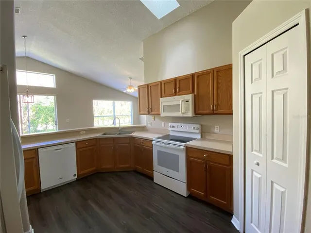 a kitchen with a sink a refrigerator a window and cabinets