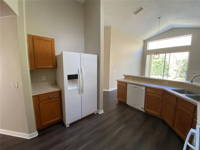 a kitchen with stainless steel appliances granite countertop a sink a stove a microwave a sink and dishwasher with wooden floor