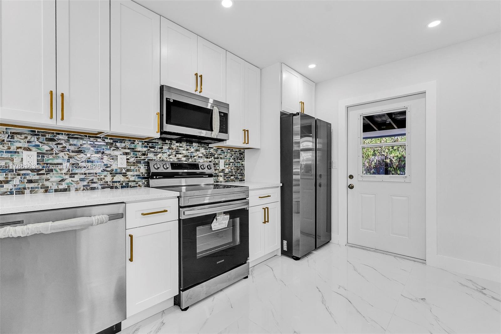 a kitchen with stainless steel appliances granite countertop a stove microwave and refrigerator