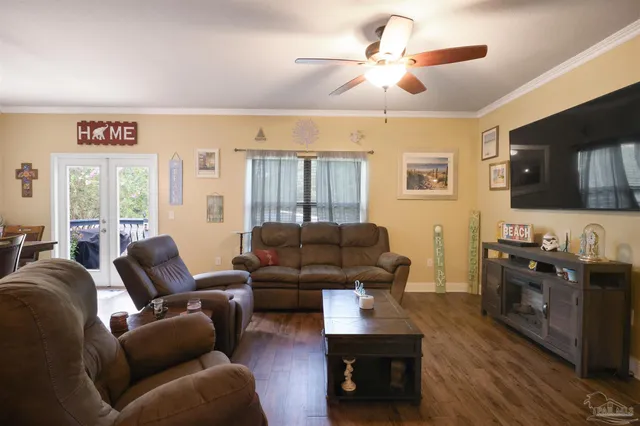 a living room with furniture a ceiling fan and a window