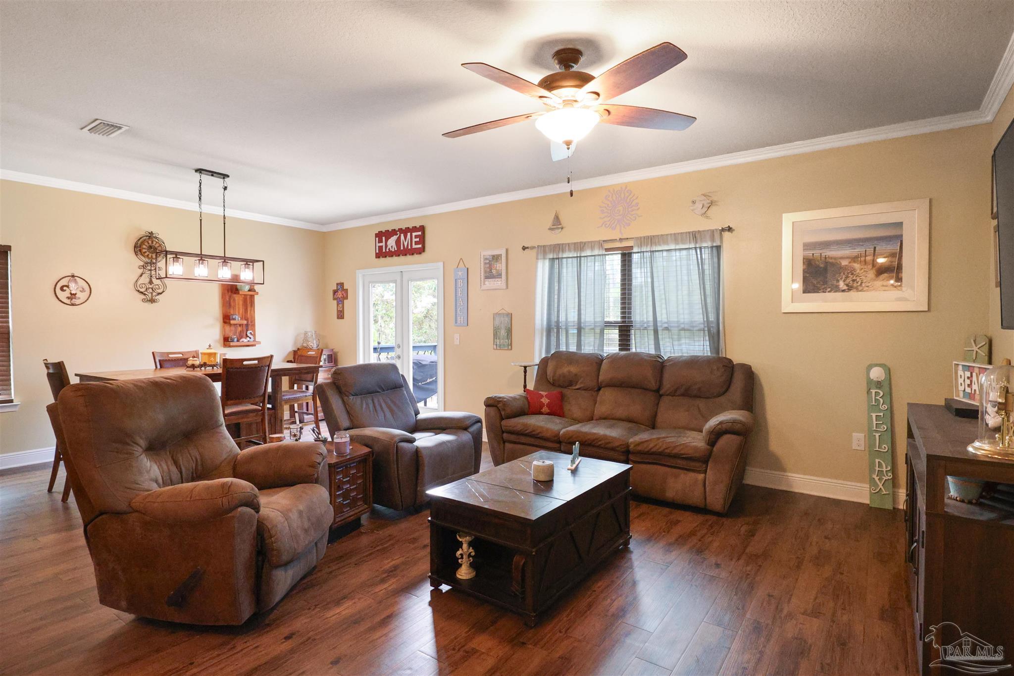 6377 Ladera Trail Pace, FL 32571 - Photo 12 of 38 a living room with furniture a ceiling fan and a window