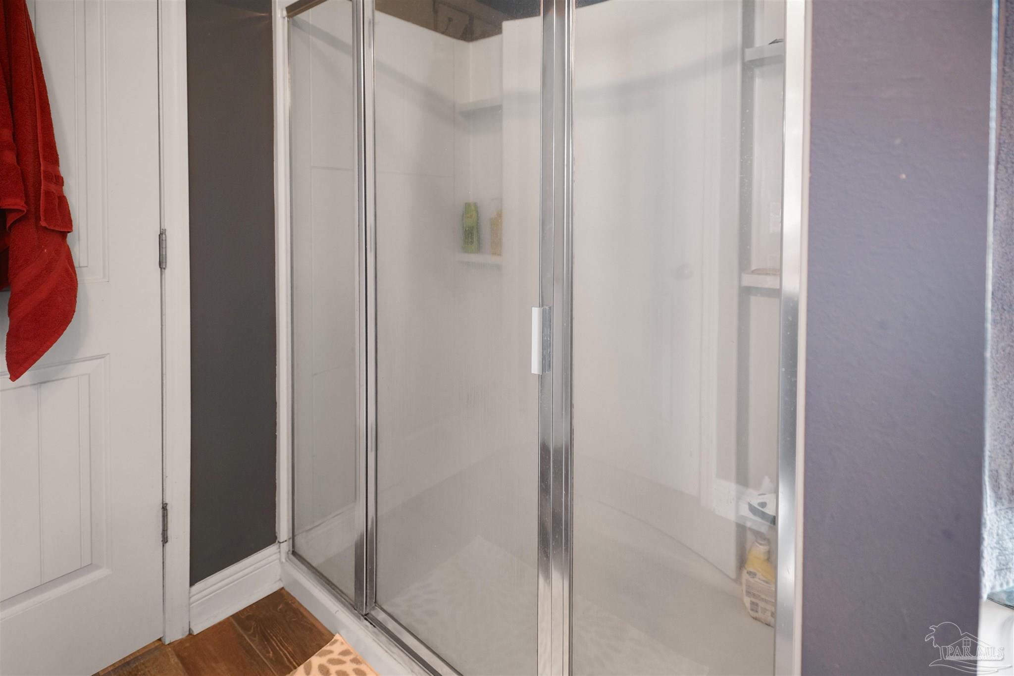 6377 Ladera Trail Pace, FL 32571 - Photo 16 of 38 a bathroom with a glass shower door