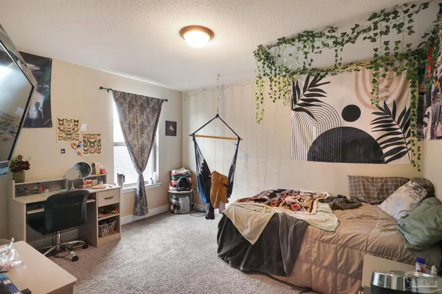 a bedroom with furniture and a large window