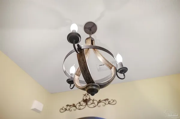 a picture of a wall with a chandelier fan and a mirror