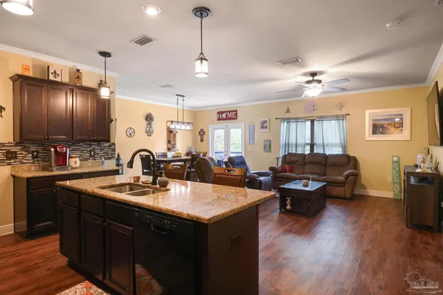 a kitchen with sink refrigerator and couches with wooden floor