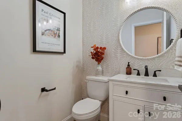 a bathroom with a toilet sink vanity and mirror