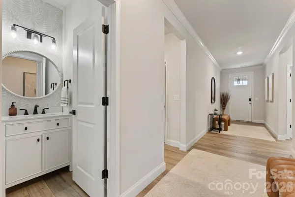 a view of a hallway with two chairs and a large mirror