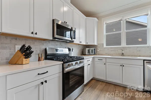 a kitchen with stainless steel appliances granite countertop a sink and a stove