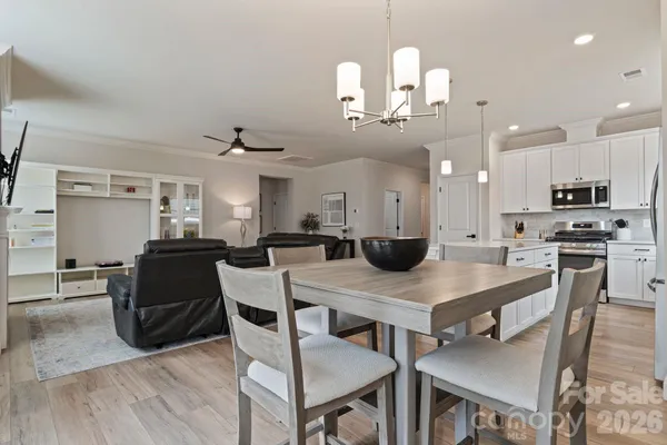 a kitchen with a dining table chairs and wooden floor