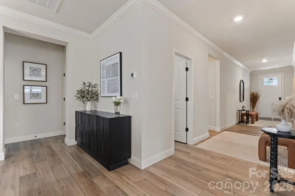 a view of a hallway with wooden floor and staircase