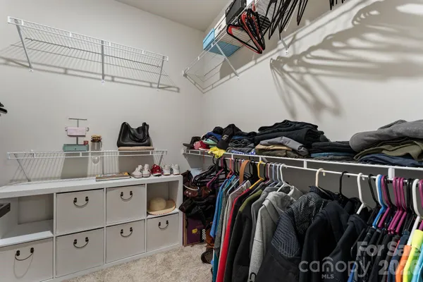 a view of walk in closet with clothes and shoes