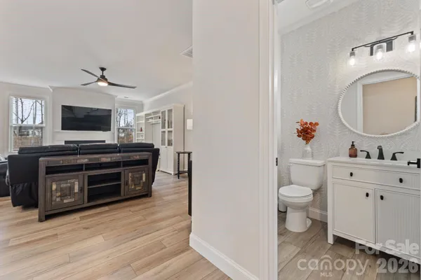 a view of a livingroom with wooden floor and a bathroom