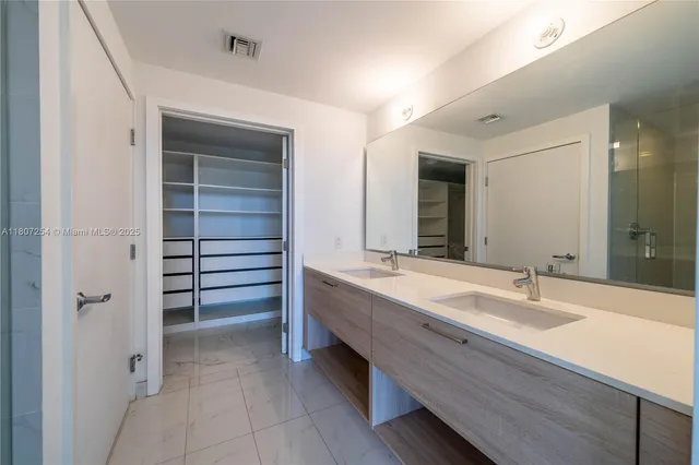 a bathroom with a double vanity sink and a mirror