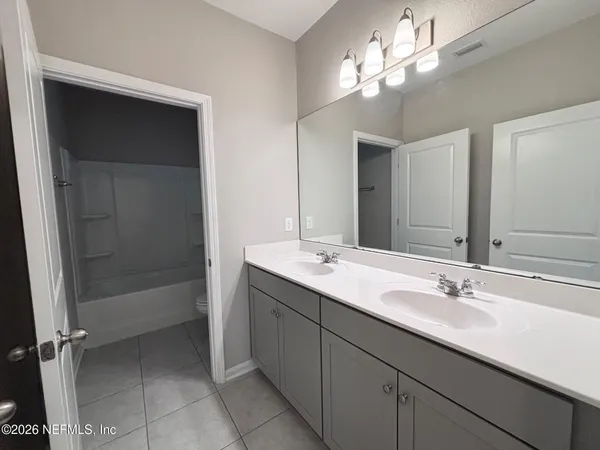 a bathroom with a double vanity sink and a mirror