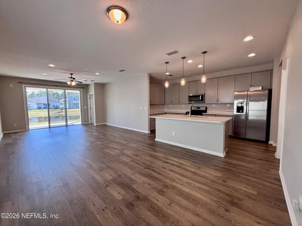 a view of an empty room with kitchen appliances and a window