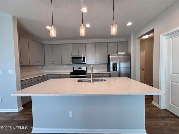 a kitchen with stainless steel appliances a refrigerator sink and microwave