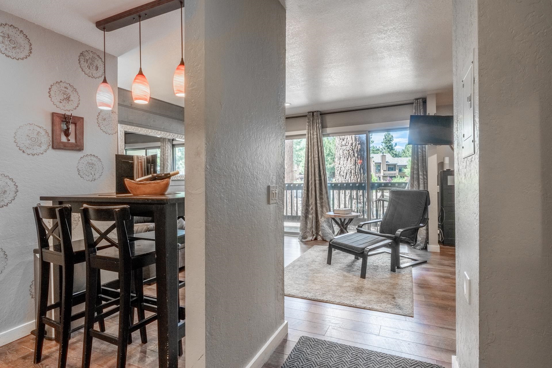 Dining room featuring a textured wall, wood finished floors, healthy amount of natural light, and a textured ceiling