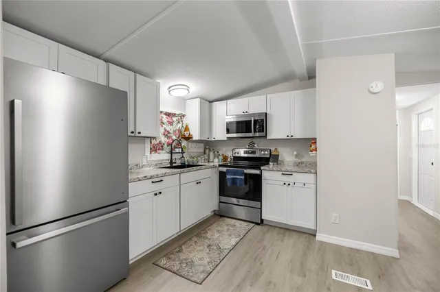 a kitchen with stainless steel appliances a refrigerator sink and microwave