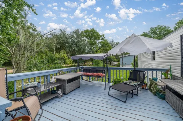 a view of a deck with furniture and a yard