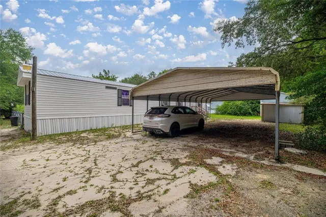 a view of a house with a backyard and a tree