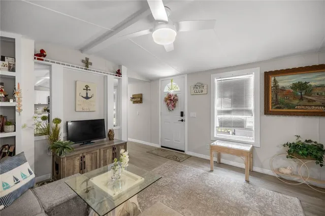 a living room with furniture a flat screen tv and a window
