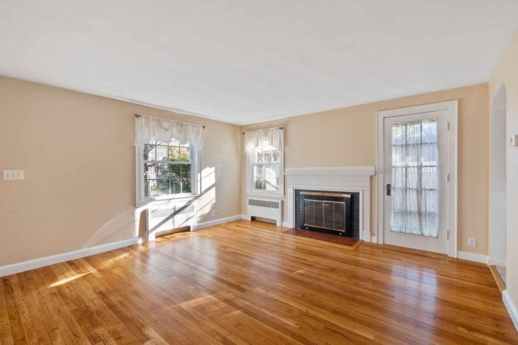 2 Craft Road Natick, MA 01760 - Photo 7 of 42 a view of a livingroom with wooden floor a fireplace and windows