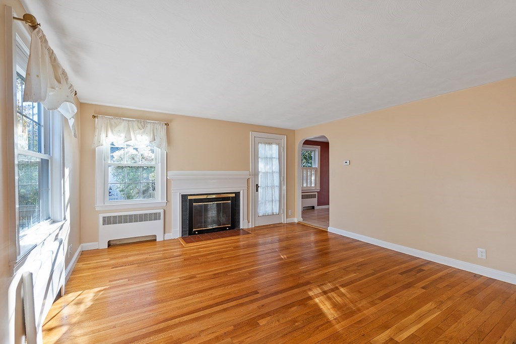 2 Craft Road Natick, MA 01760 - Photo 8 of 42 a view of empty room with wooden floor and fireplace
