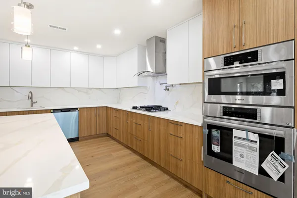a kitchen with stainless steel appliances kitchen island granite countertop a refrigerator and a stove top oven