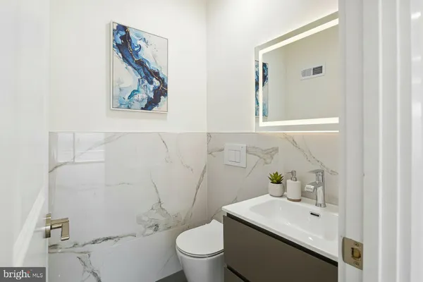 a bathroom with a toilet a sink and mirror