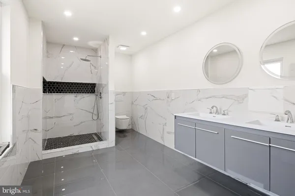 a bathroom with a double vanity sink mirror and shower