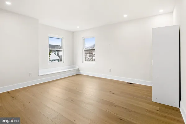 an empty room with wooden floor and window