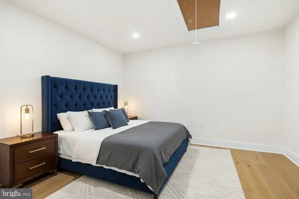 a view of an empty room with wooden floor and closet
