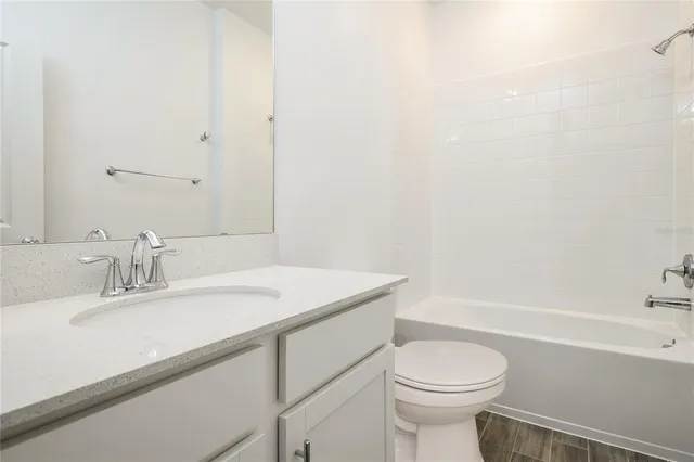 a bathroom with a sink toilet vanity and tub