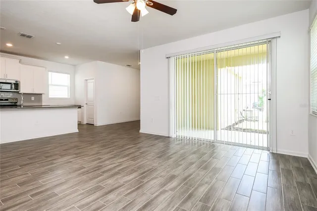 a view of a kitchen with a stove wooden floor and cabinets