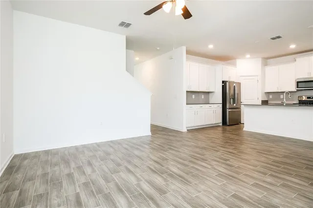 a view of a kitchen with a refrigerator and a stove top oven